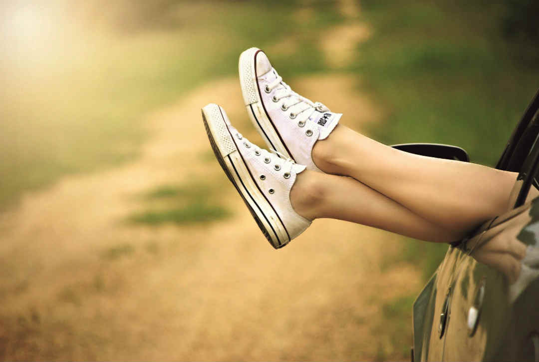 Womans feet hanging outside a car window